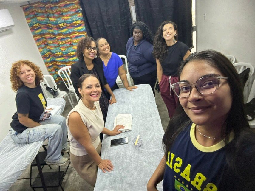 Turma formada pelo Instituto Ayó posa de beca e faixa roxa segurando os certificados no dia da formatura