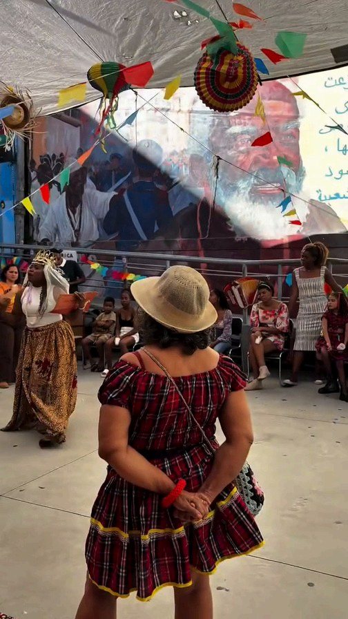 Festa junina do Arraiá das Pretas com bandeirinhas coloridas e participantes reunidos no pátio